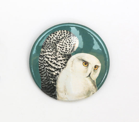 Green pin badge with illustration of two snowy owls